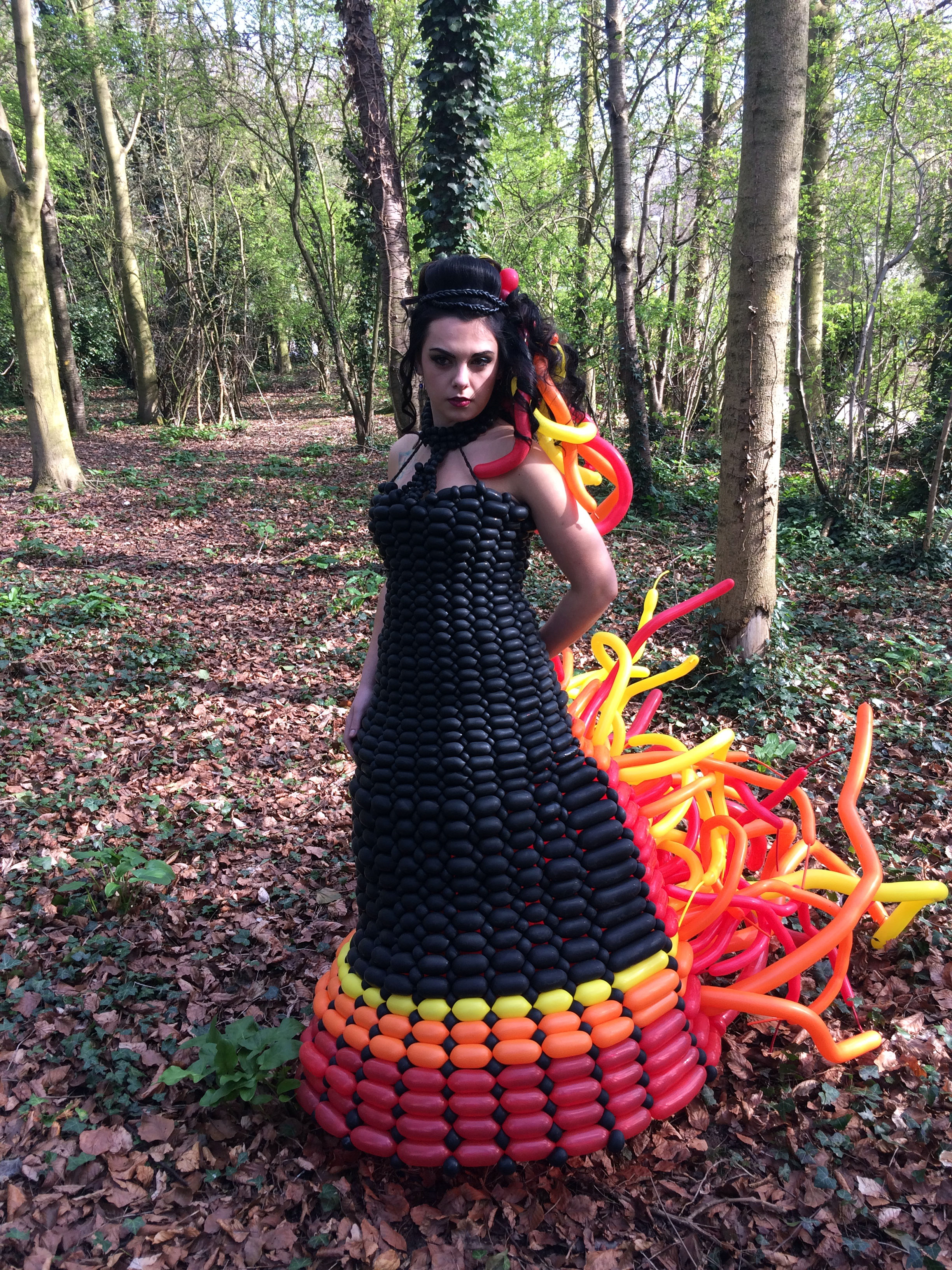 Girl wearing hunger games dress in forest side view